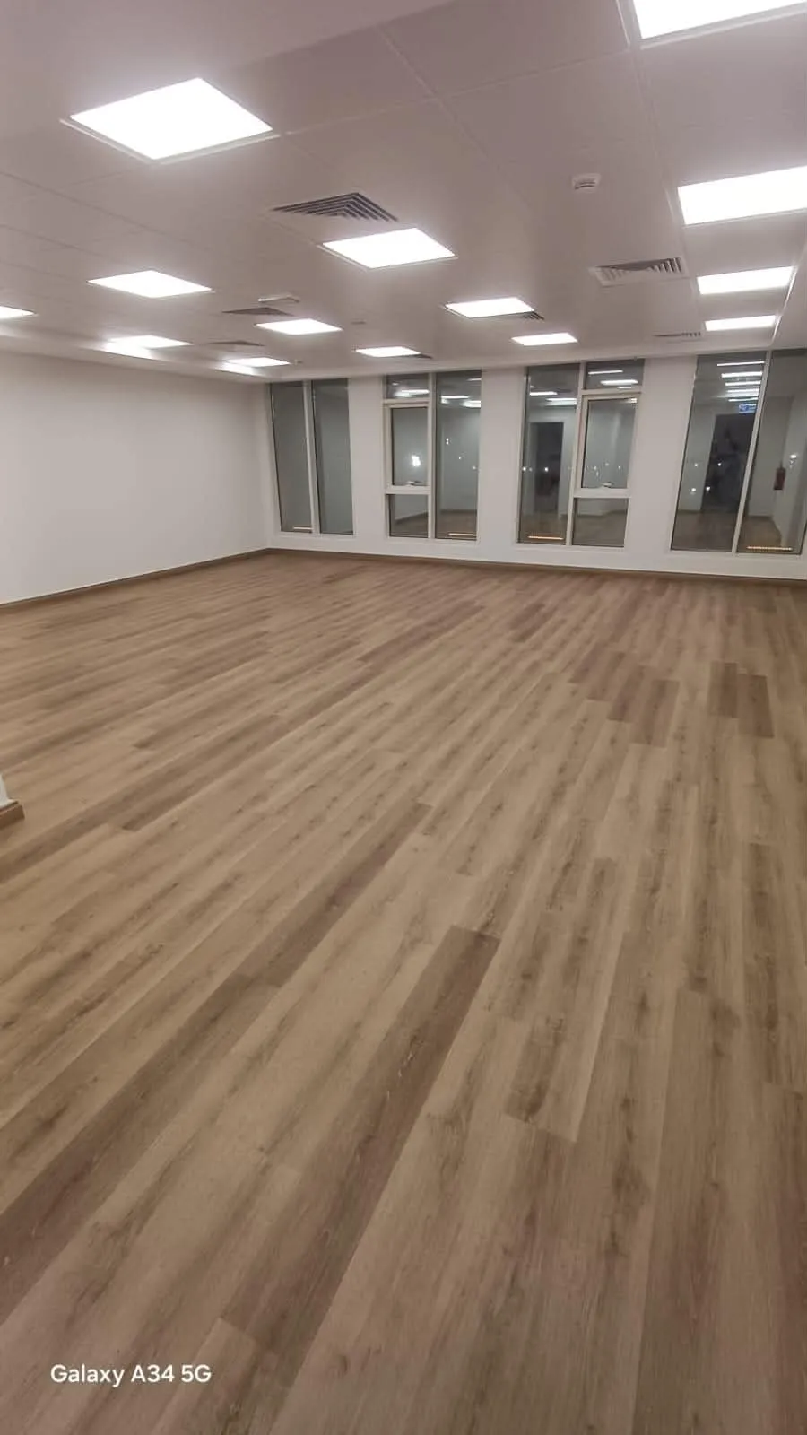 Wood-look vinyl plank flooring across an open office floor in Qatar