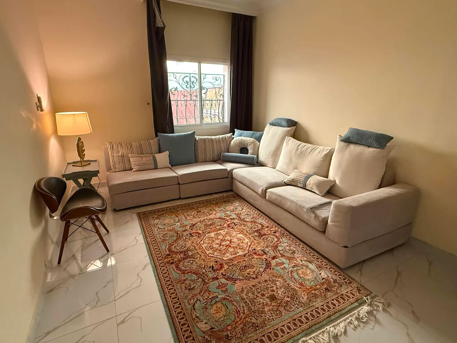 Cream corner sofa with scatter cushions on a marble floor