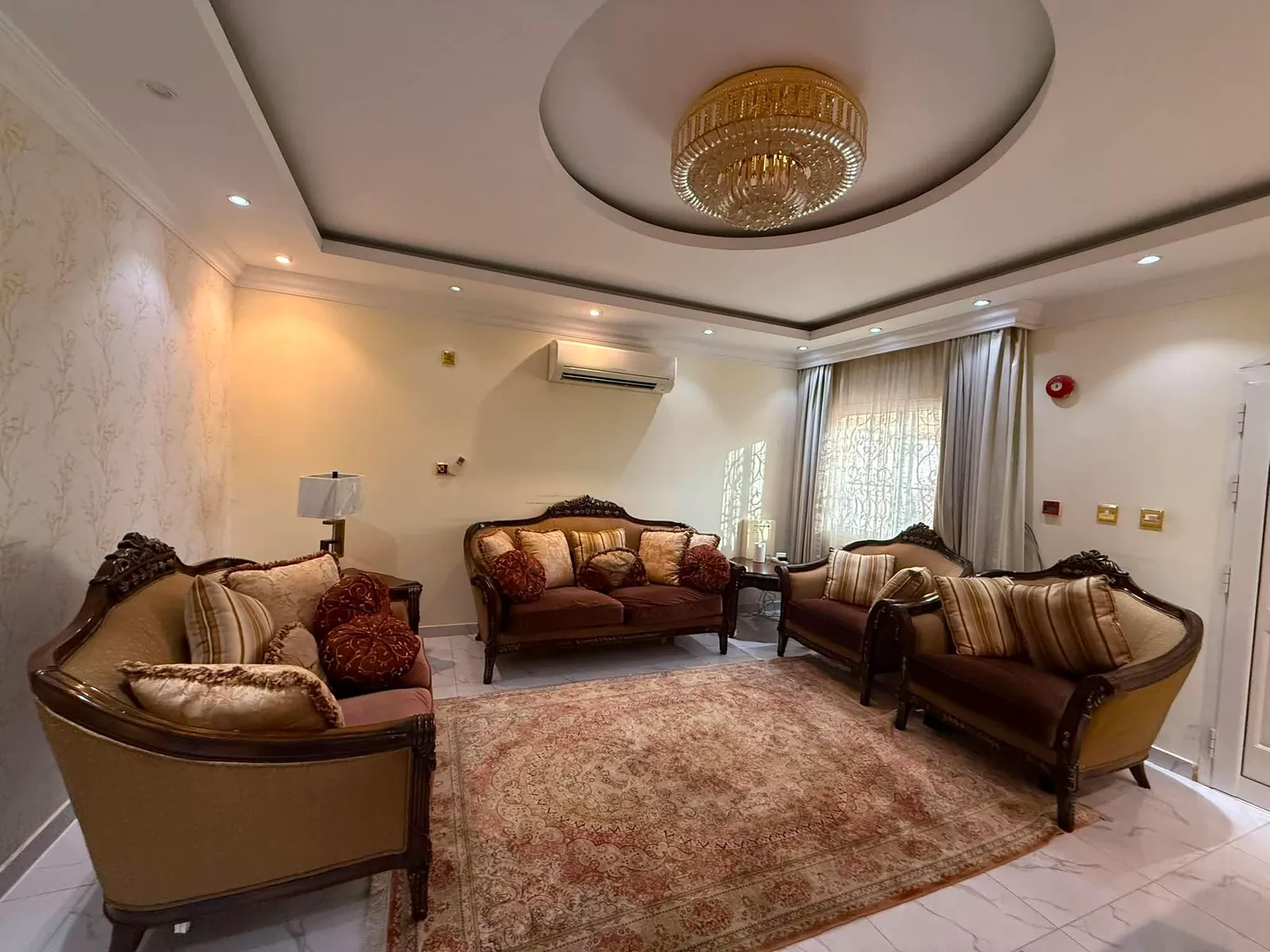 Formal majlis seating with carved wood frames under a chandelier