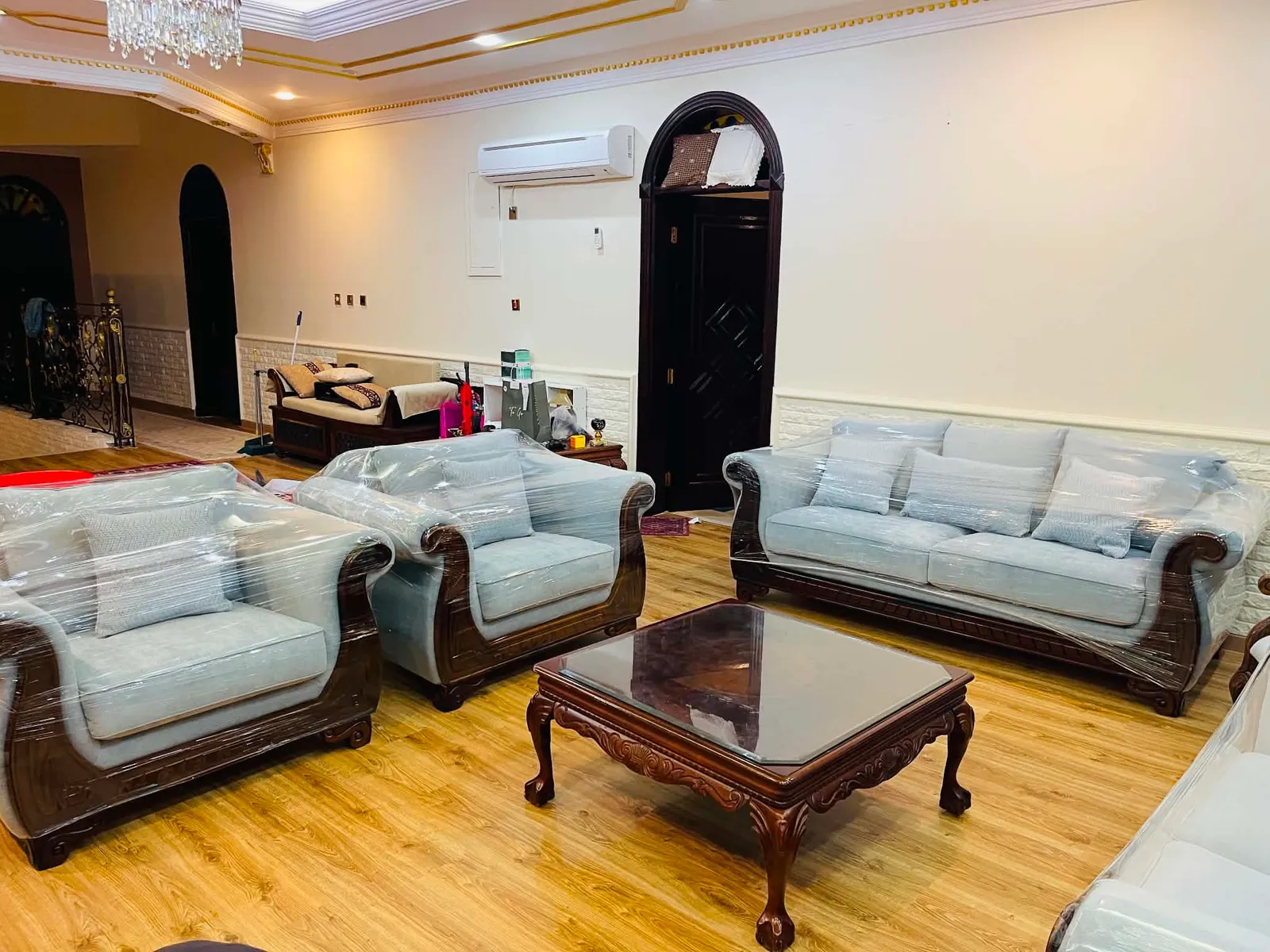 Reupholstered pale blue armchairs and sofa around a carved coffee table